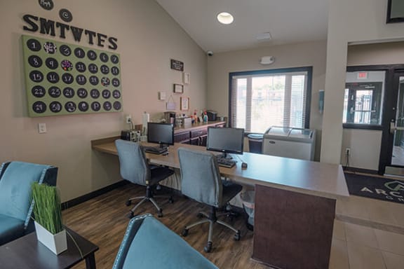 a office with three desks and chairs and a window