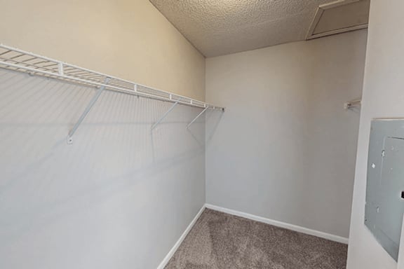 A white wall with a metal shelf on it.