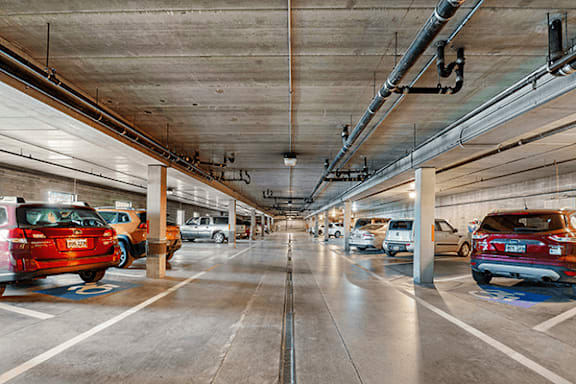 A parking garage with cars parked on both sides.