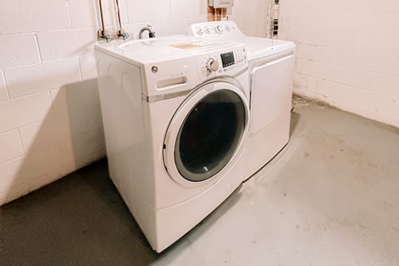 a white washing machine and dryer in a white room
