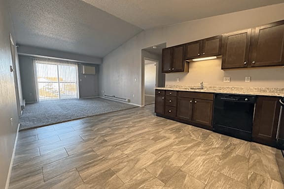 A kitchen with wooden flooring and a stove top oven.