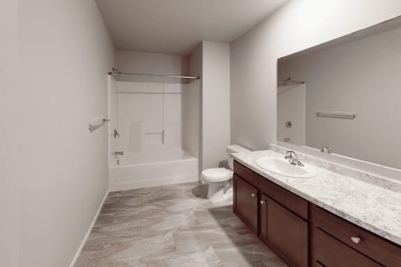 A bathroom with a toilet, sink, and shower.