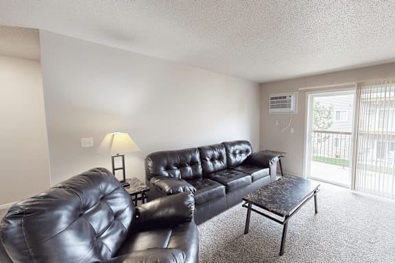 A black leather couch and chair in a living room.