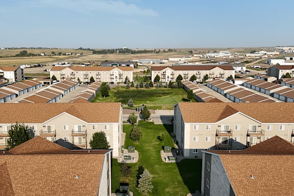 A large housing complex with multiple buildings and a green lawn in the center.