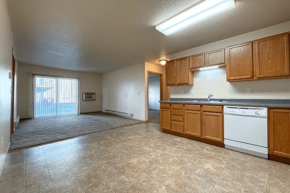A kitchen with wooden cabinets and a white dishwasher.