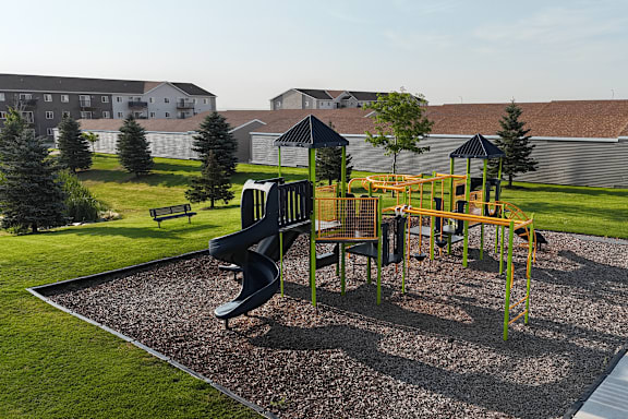 A playground with a yellow and black slide.