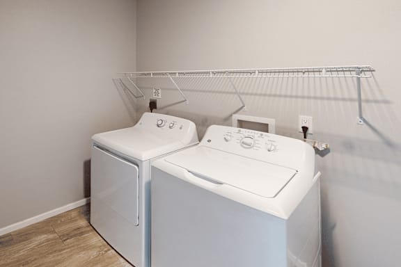 Two white washing machines in a laundry room.