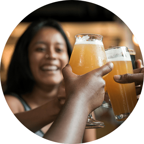 a woman holding up two glasses of beer