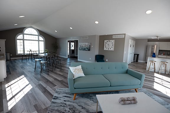 a living room with a blue couch and a table and chairs