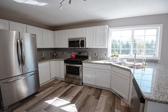 a kitchen with white cabinets and stainless steel appliances