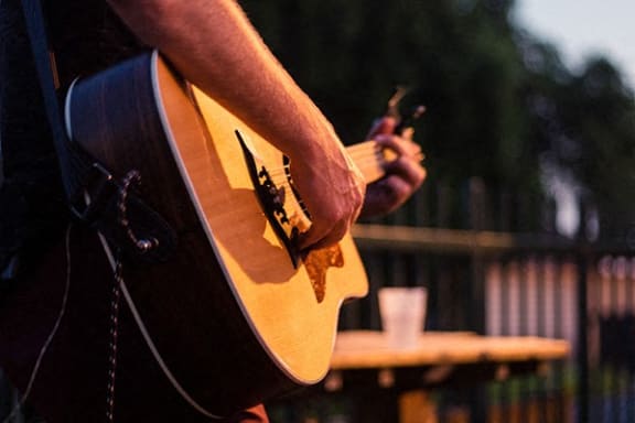 a person holding a guitar in their hand