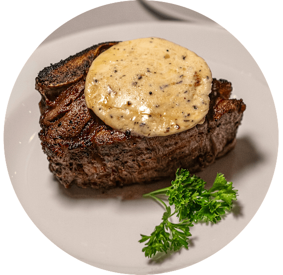 A steak with a creamy sauce and parsley on a white plate.