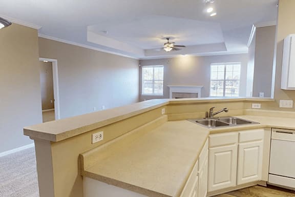 an empty kitchen with a sink and a counter top