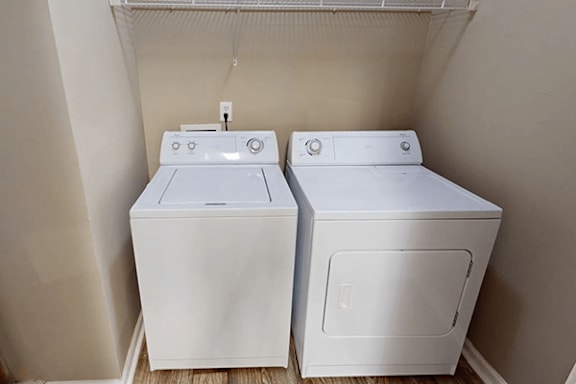 two washes and a dryer in a room with a window