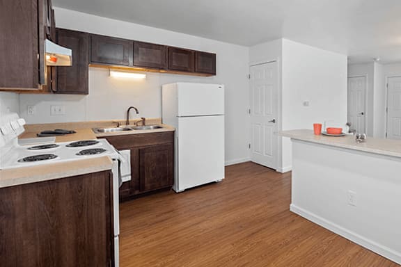 A kitchen with a white fridge and wooden cabinets.