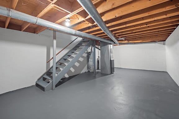 A staircase in a room with wooden beams on the ceiling.