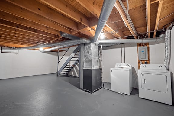A room with a staircase and a washing machine.