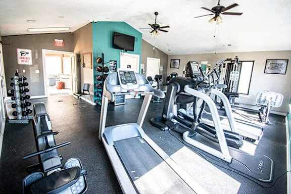 A gym with treadmills, weights, and exercise equipment.