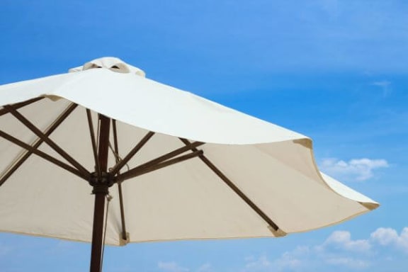 a large white umbrella with a blue sky in the background