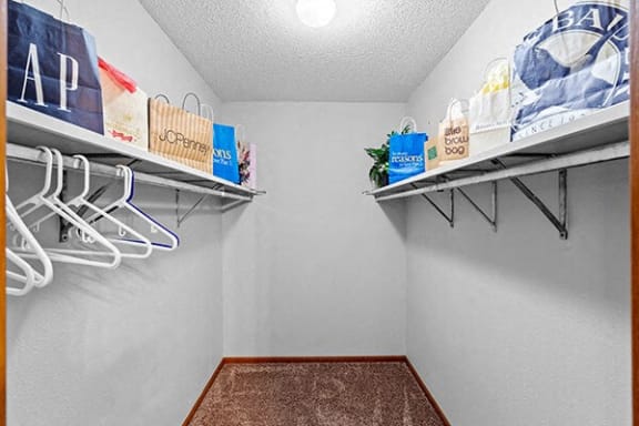 a closet with shelves and hangers on the walls