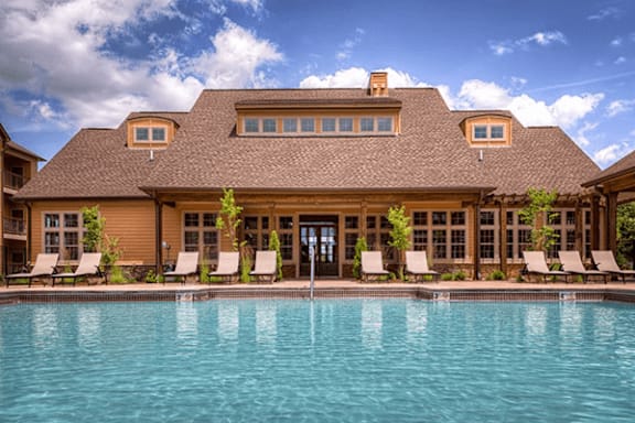 A large house with a pool in front.
