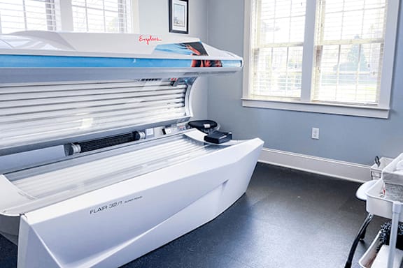 A Flair 3271 tanning bed in a room with a window.