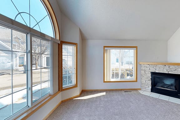 A living room with a fireplace and a large window.