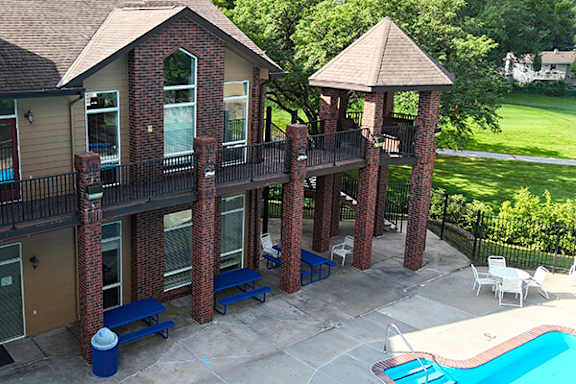 A pool and patio area with a gazebo and chairs.