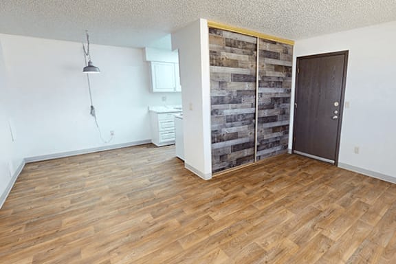 A room with wooden flooring and a wooden wall panel.