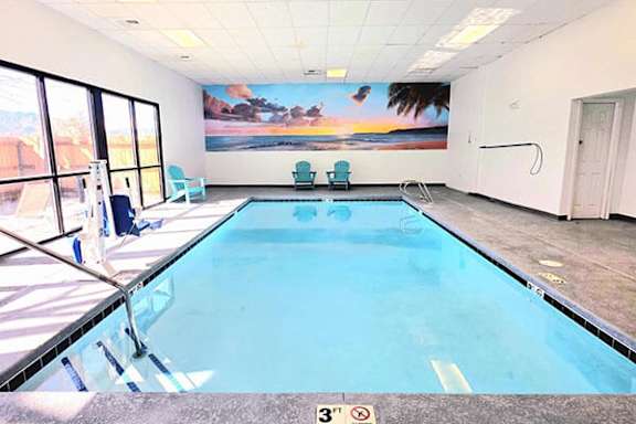A large indoor swimming pool with a 3 feet depth sign.
