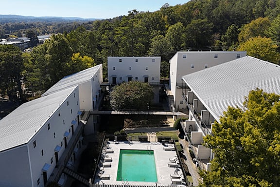 arial view of two buildings with a pool in the middle