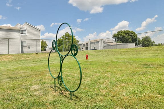 a green metal sculpture in the middle of a field