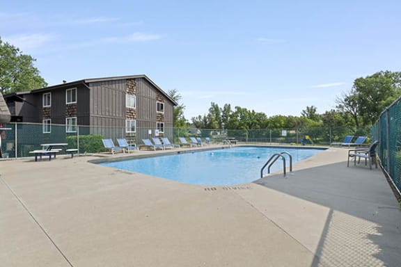 a pool with a fence around it and a building in the background