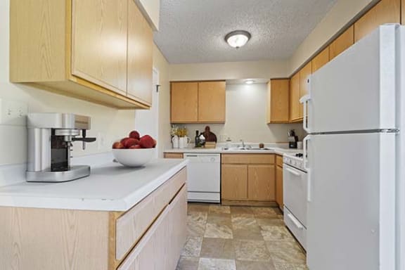 a kitchen with a white refrigerator freezer next to a stove top oven