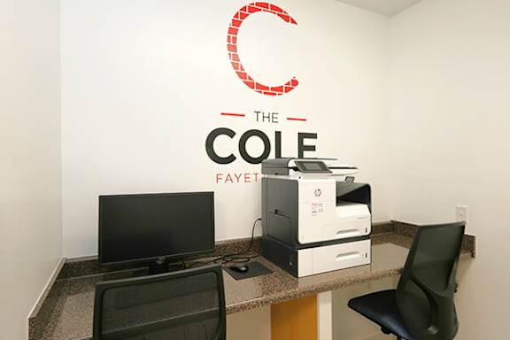 A white wall with a red logo and the words "The Cole Fayet" written on it.