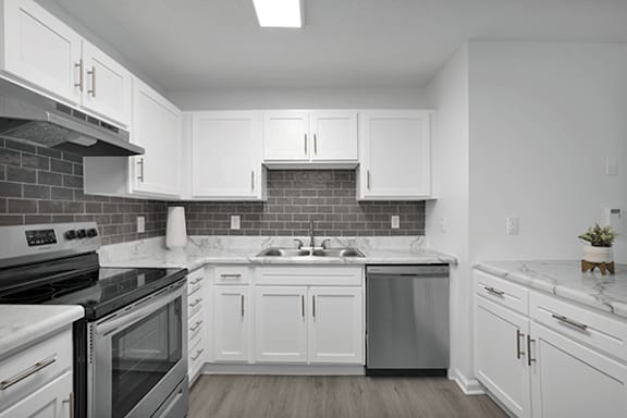 A kitchen with white cabinets and a black stove top oven.