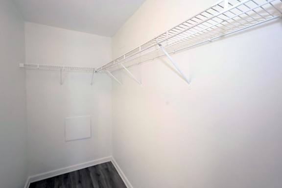 A white closet with a shelf and a white square on the wall.