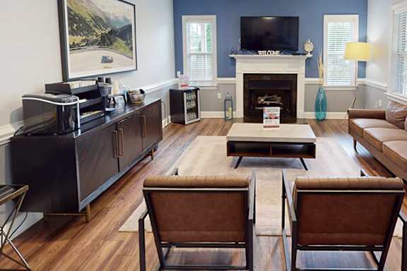 A living room with a fireplace and a painting on the wall.