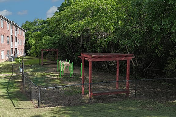 A playground with a red swing set and green monkey bars.
