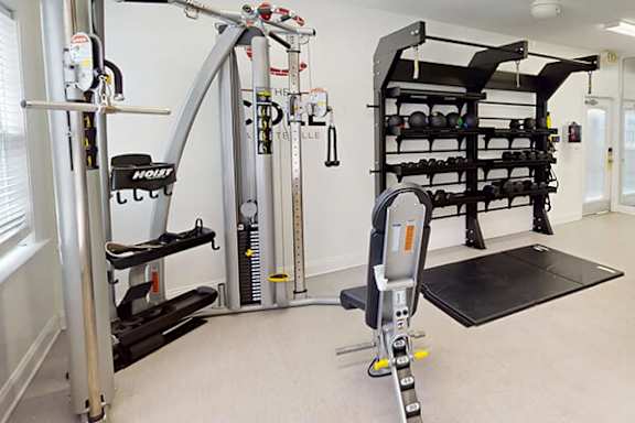 A home gym with a weight rack, a squat rack, and a bench.