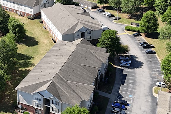 A parking lot with cars and a building in the background.
