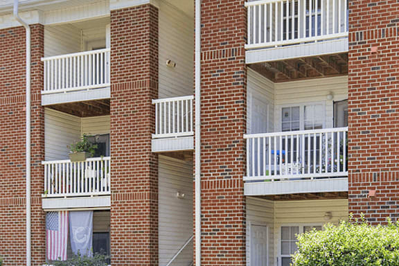 Two red brick buildings with white balconies.