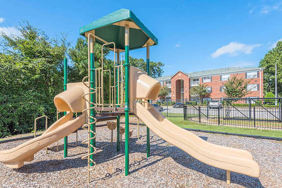 A playground with a green roof and a yellow slide.