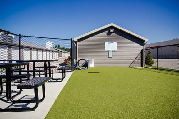 a dog park with a picnic table and picnic table bench in front of a building