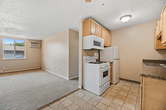 A kitchen with a white stove and microwave.