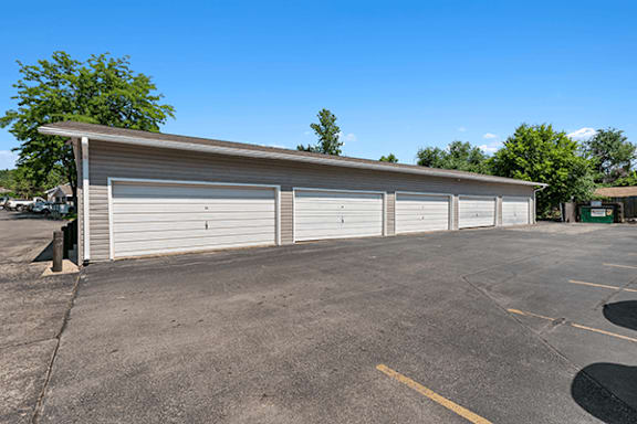 A long building with a grey roof and white garage doors.
