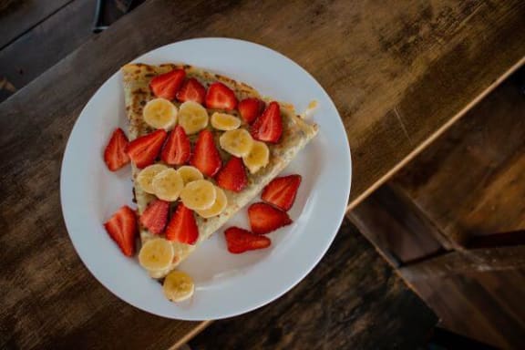 a plate with a slice of cake with strawberries and bananas on it