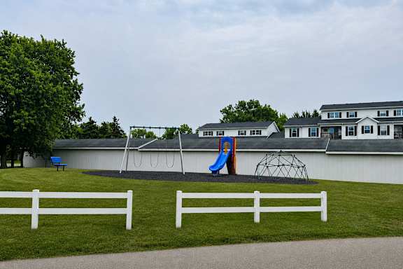 A playground with a slide and a swing set.