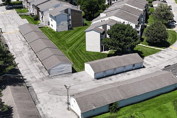 A long row of houses with a green lawn in between.