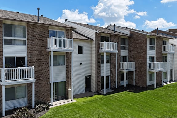 A row of apartment buildings with balconies and doors.